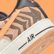 Nike Air Force 1 Low Daktari, sneaker en cuir Coconut Milk avec empiècements en suède zébré orange, Swoosh orange et semelle gomme.