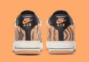 Nike Air Force 1 Low Daktari, sneaker en cuir Coconut Milk avec empiècements en suède zébré orange, Swoosh orange et semelle gomme.