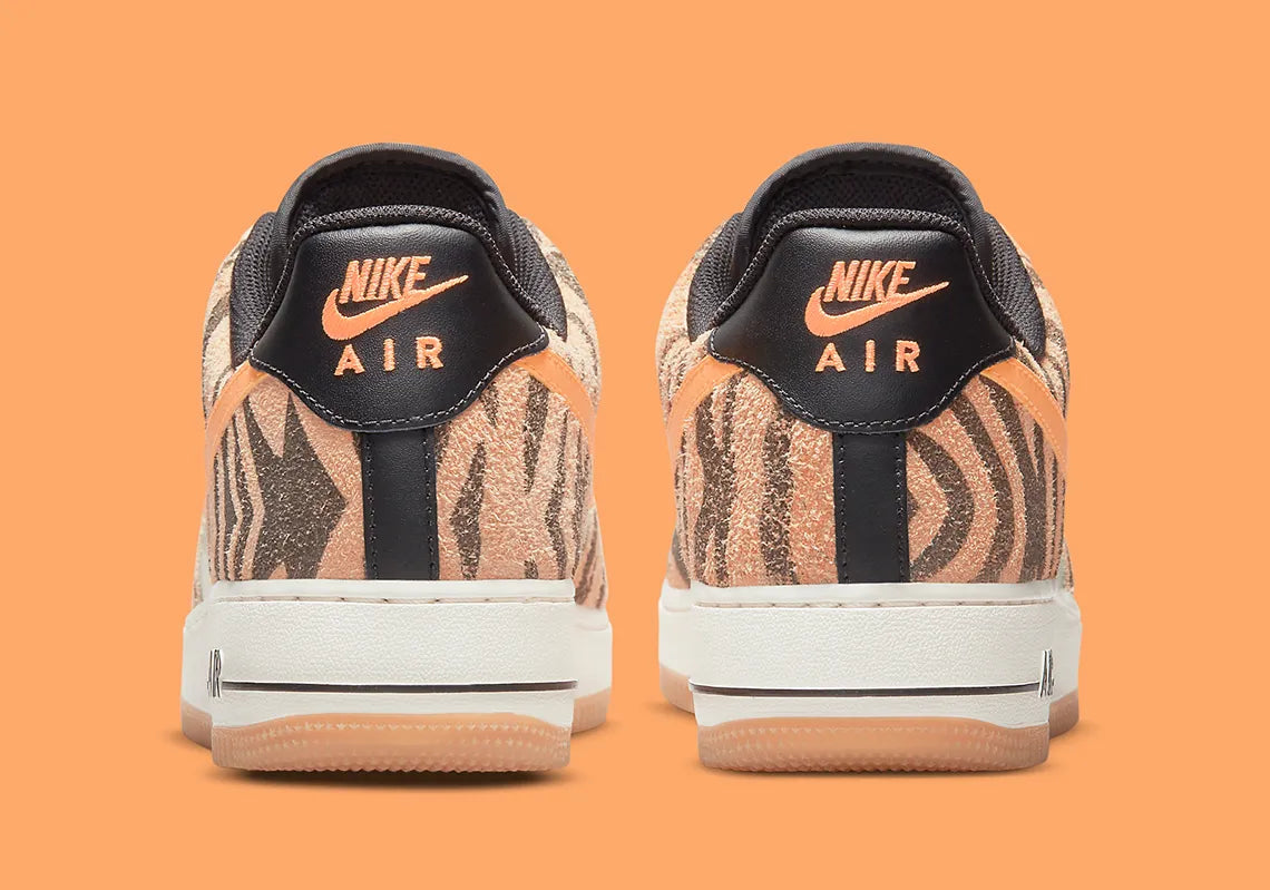 Nike Air Force 1 Low Daktari, sneaker en cuir Coconut Milk avec empiècements en suède zébré orange, Swoosh orange et semelle gomme.
