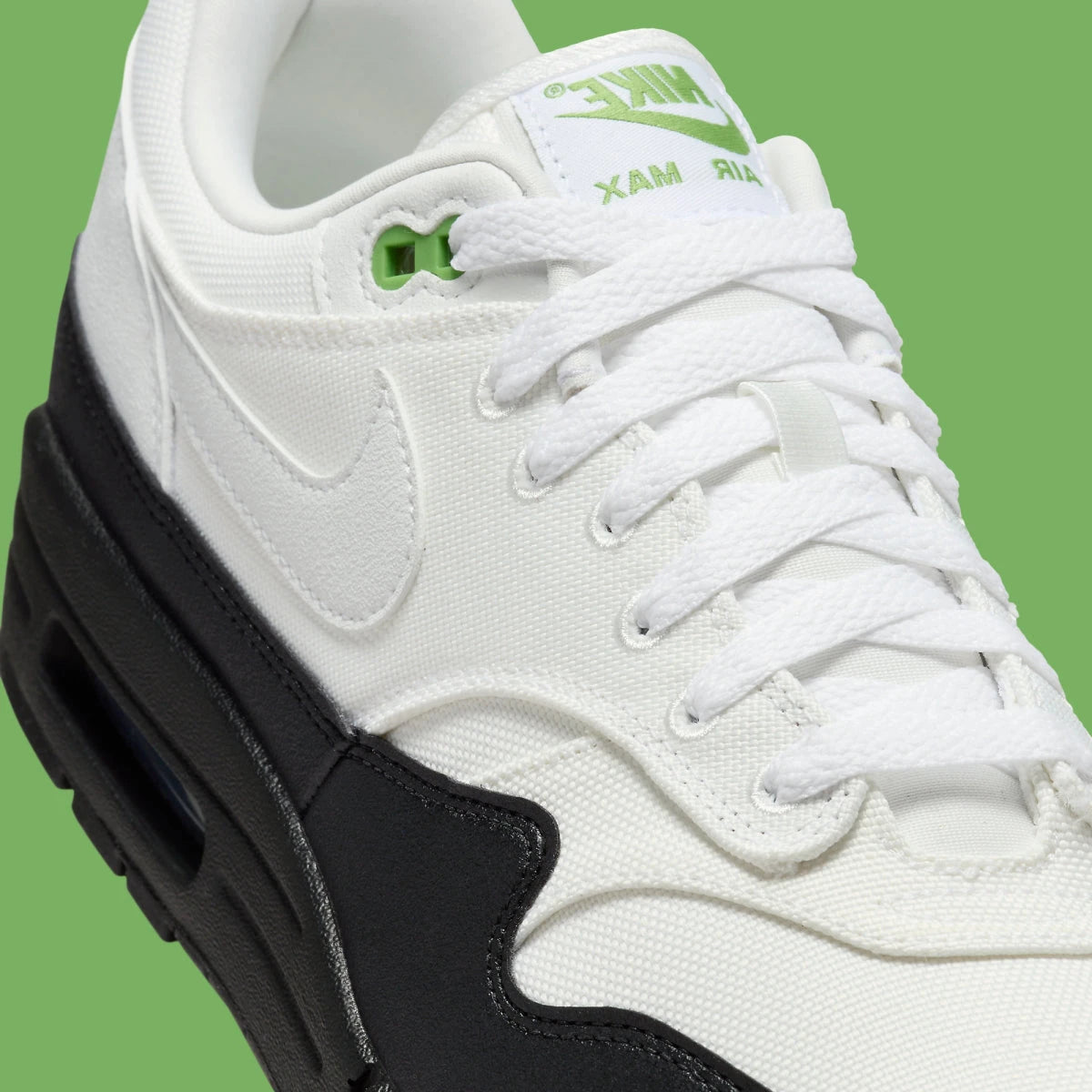Sneakers Nike Air Max 1 White Black Chlorophyll en matériaux premium avec unité Air visible et détails contrastés iconiques vue zoomée sur les détails du profil de la paire. 