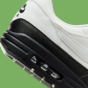 Sneakers Nike Air Max 1 White Black Chlorophyll en matériaux premium avec unité Air visible et détails contrastés iconiques vue zoomée sur les détails arrière de la paire. 