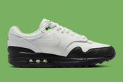 Sneakers Nike Air Max 1 White Black Chlorophyll en matériaux premium avec unité Air visible et détails contrastés iconiques vue de profil intérieur. 