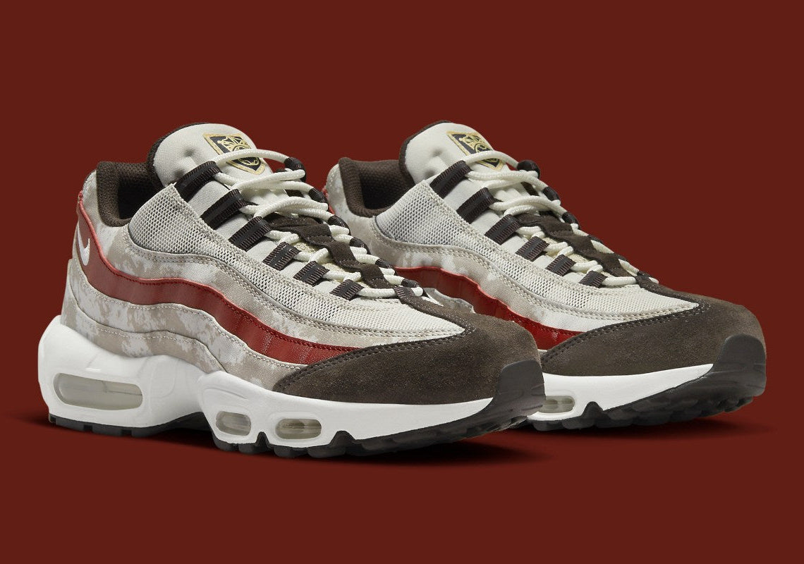 Nike Air Max 95 Social FC DQ9016-001, sneaker beige, marron et bordeaux avec motif camouflage, écusson football et unités Nike Air visibles.