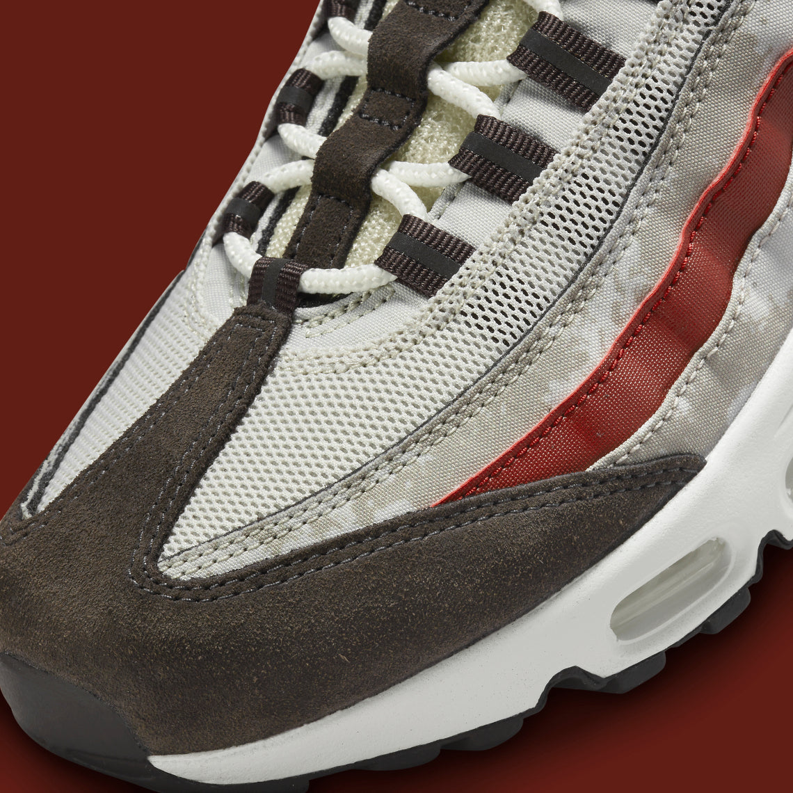 Nike Air Max 95 Social FC DQ9016-001, sneaker beige, marron et bordeaux avec motif camouflage, écusson football et unités Nike Air visibles.