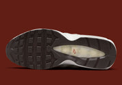 Nike Air Max 95 Social FC DQ9016-001, sneaker beige, marron et bordeaux avec motif camouflage, écusson football et unités Nike Air visibles.