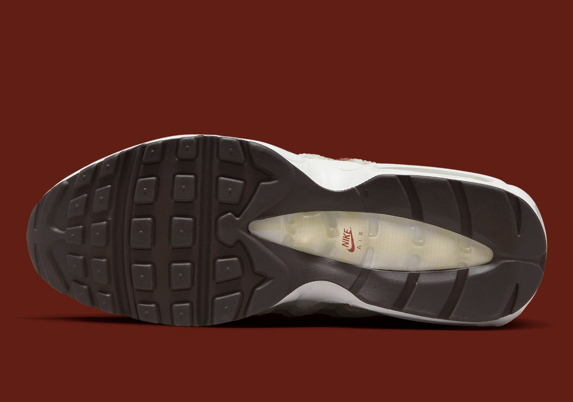 Nike Air Max 95 Social FC DQ9016-001, sneaker beige, marron et bordeaux avec motif camouflage, écusson football et unités Nike Air visibles.