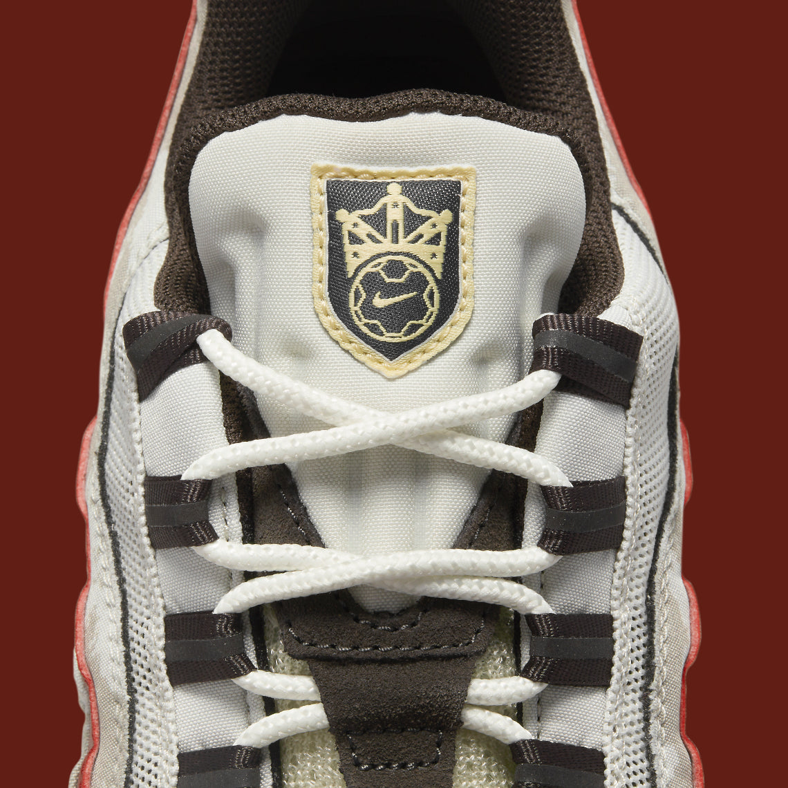 Nike Air Max 95 Social FC DQ9016-001, sneaker beige, marron et bordeaux avec motif camouflage, écusson football et unités Nike Air visibles.