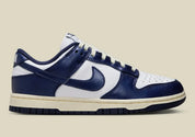 Nike Dunk Low PRM Vintage Navy, sneaker en cuir blanc et bleu marine avec Swoosh bleu et semelle crème effet vintage.
