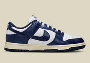 Nike Dunk Low PRM Vintage Navy, sneaker en cuir blanc et bleu marine avec Swoosh bleu et semelle crème effet vintage.