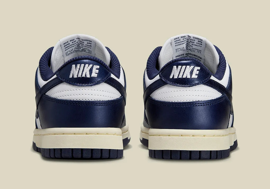 Nike Dunk Low PRM Vintage Navy, sneaker en cuir blanc et bleu marine avec Swoosh bleu et semelle crème effet vintage.