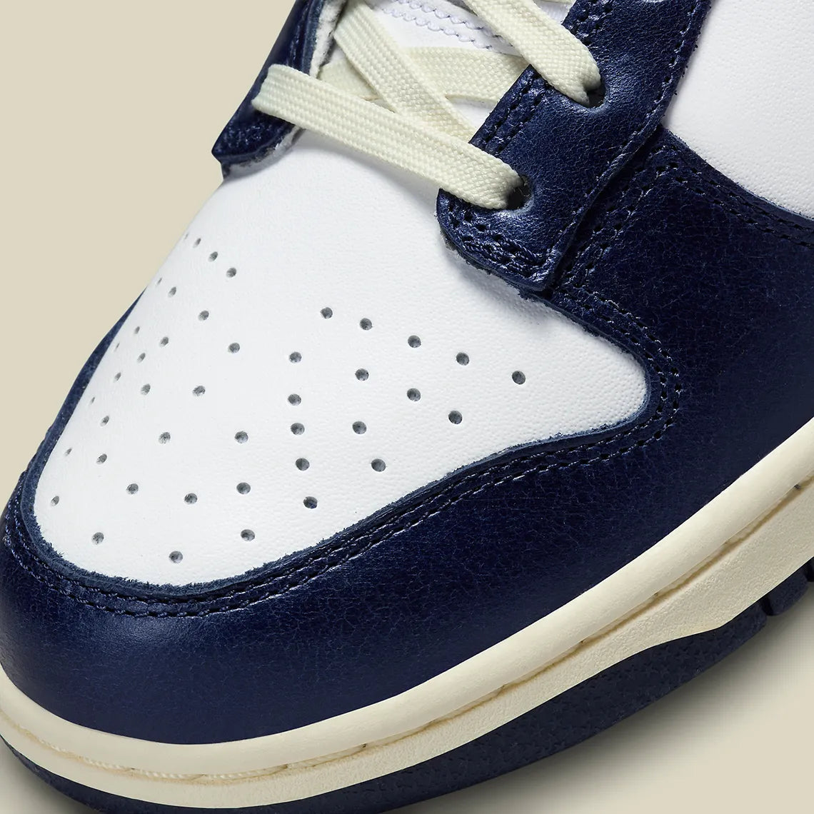 Nike Dunk Low PRM Vintage Navy, sneaker en cuir blanc et bleu marine avec Swoosh bleu et semelle crème effet vintage.