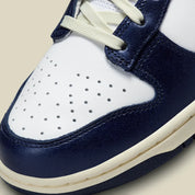 Nike Dunk Low PRM Vintage Navy, sneaker en cuir blanc et bleu marine avec Swoosh bleu et semelle crème effet vintage.