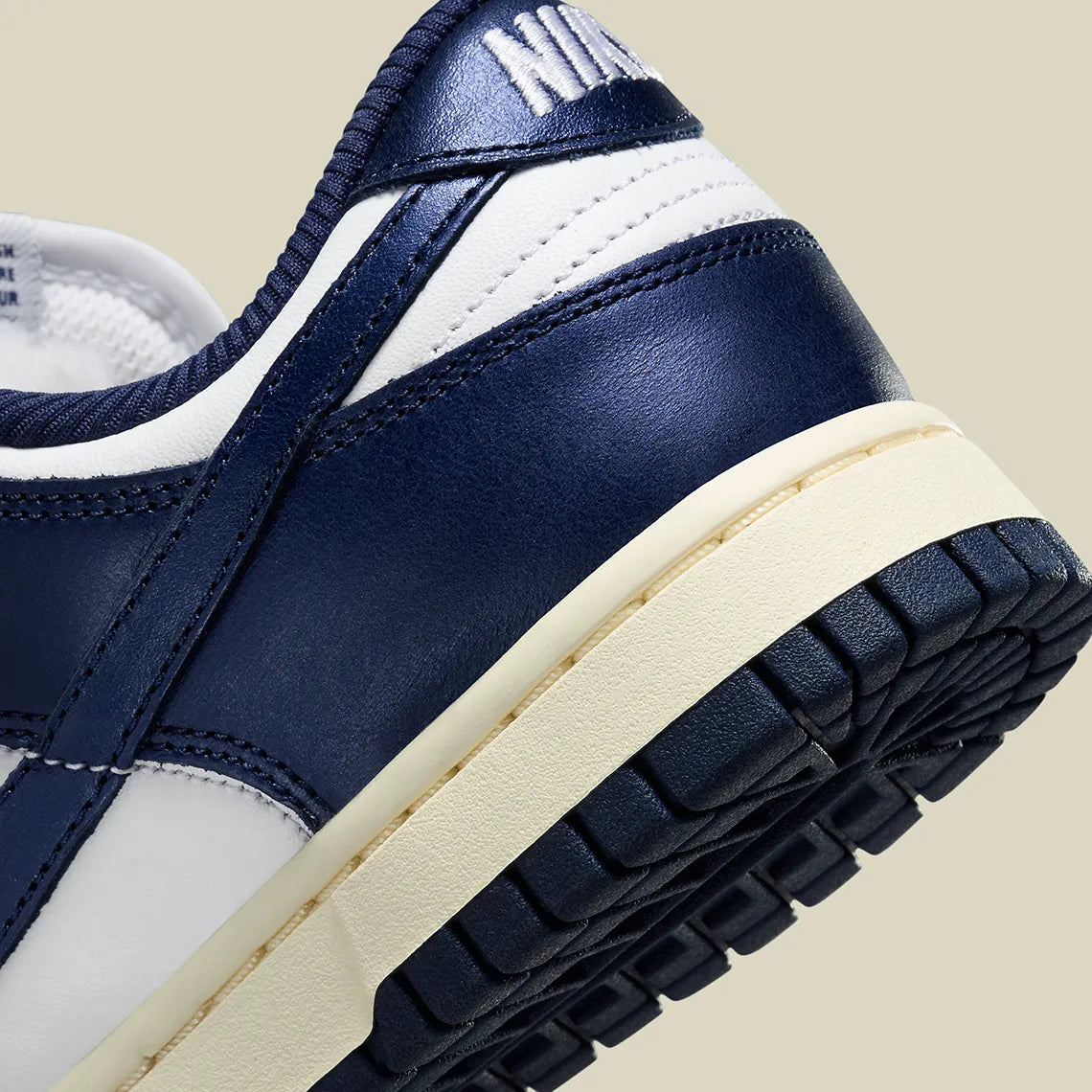 Nike Dunk Low PRM Vintage Navy, sneaker en cuir blanc et bleu marine avec Swoosh bleu et semelle crème effet vintage.