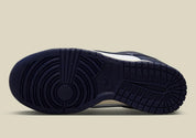 Nike Dunk Low PRM Vintage Navy, sneaker en cuir blanc et bleu marine avec Swoosh bleu et semelle crème effet vintage.