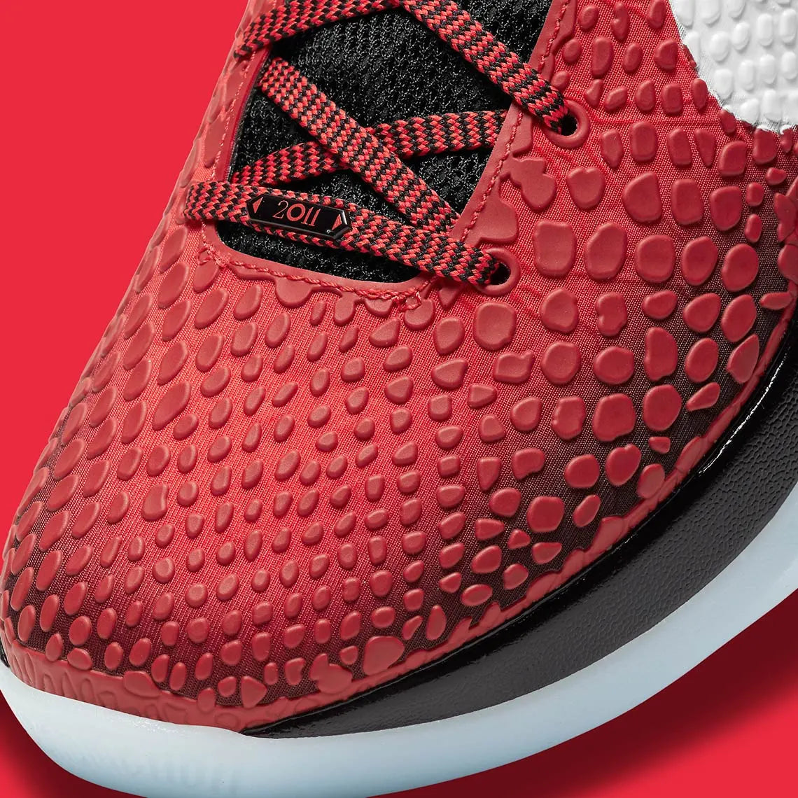 Image de la Nike Kobe 6 Protro ‘Challenge Red All-Star’ – chaussure de basketball rouge vif avec texture snakeskin, accents noirs et blancs, amorti Zoom Air Turbo, semelle traction compacte. Vue zoomée sur la toe box.
