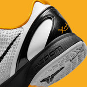 Image de la Nike Kobe 6 Protro “White Del Sol” (CW2190-100), sneaker blanche/grise avec accents noirs, texture îlots polyuréthane, unité Zoom Air Turbo avant-pied, semelle traction peau de serpent. Vue zoomée sur l'arrière de la paire.