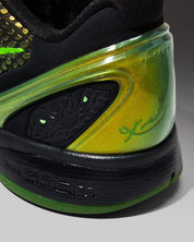Image de la Nike Kobe 6 Supreme Rice, sneaker de basketball vert métallisé avec détails noirs et dorés, tige texturée en écaille de serpent, semelle Zoom Air et logo “R” au talon. Vue zoomée sur les détails arrières de la paire.