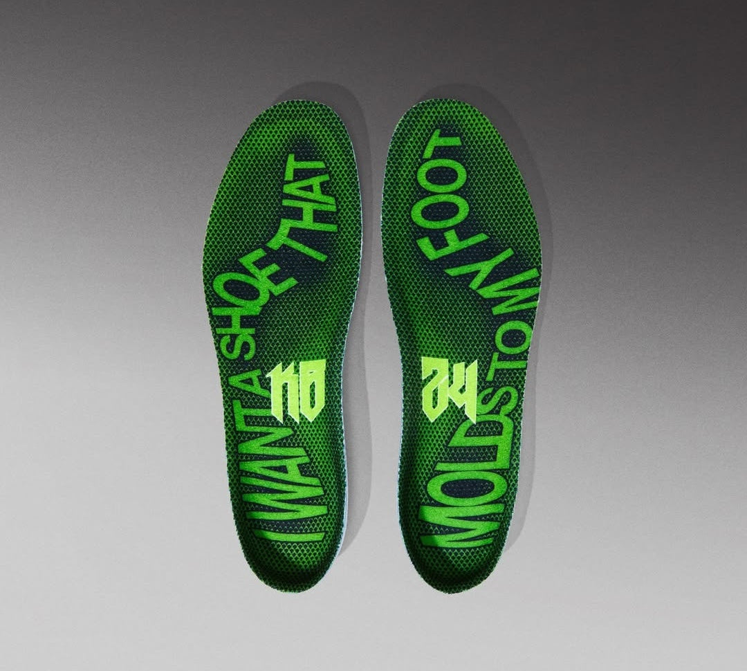 Image de la Nike Kobe 6 Supreme Rice, sneaker de basketball vert métallisé avec détails noirs et dorés, tige texturée en écaille de serpent, semelle Zoom Air et logo “R” au talon. Vue sur les semelles intérieures de la paire.