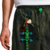 Nike ACG x CPFM Pant Multicolor, pantalon streetwear ample multicolore avec imprimé effet taches d’huile et détails techniques ACG.