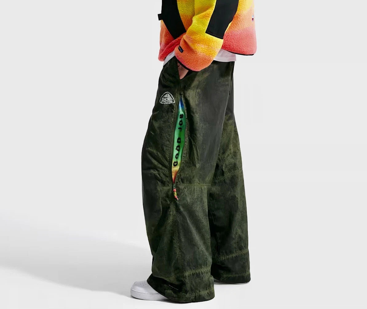 Nike ACG x CPFM Pant Multicolor, pantalon streetwear ample multicolore avec imprimé effet taches d’huile et détails techniques ACG.
