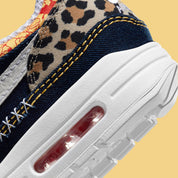Nike Air Max 1 Premium Denim Leopard, sneaker en denim bleu avec détails léopard, empiècements en suède et unité Air visible. (zoom arrière de la chaussure)