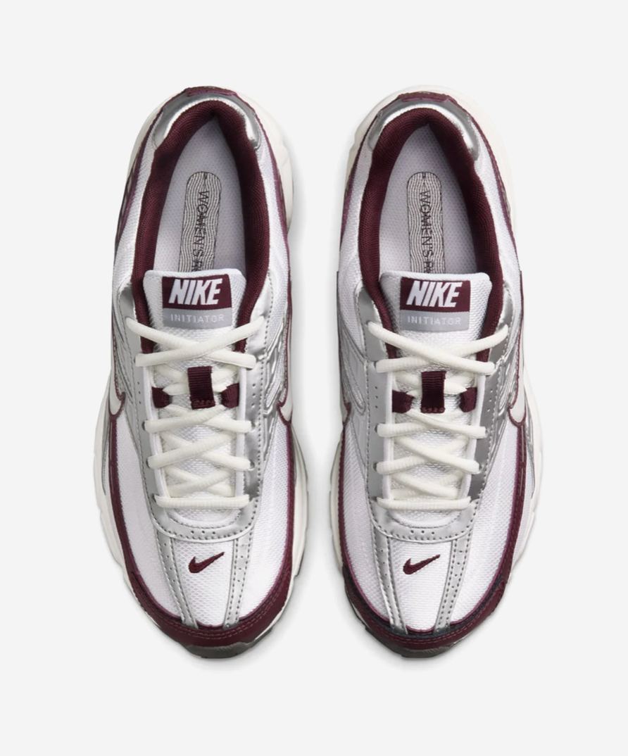 Nike Initiator White Sail Burgundy avec tige blanche et crème en mesh, empiècements structurés et détails bordeaux.