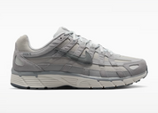 Nike P-6000 SE Pure Platinum Wolf Grey Summit White grise et blanche avec textile respirant, renforts en cuir synthétique et semelle en mousse vue de profil. 