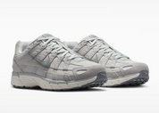 Nike P-6000 SE Pure Platinum Wolf Grey Summit White grise et blanche avec textile respirant, renforts en cuir synthétique et semelle en mousse vue de 3/4 face. 