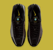 Nike Shox R4 Brazil avec tige en mesh noir et empiècements synthétiques, détails Canary et Light Photo Blue, amorti Nike Shox et semelle extérieure en caoutchouc.