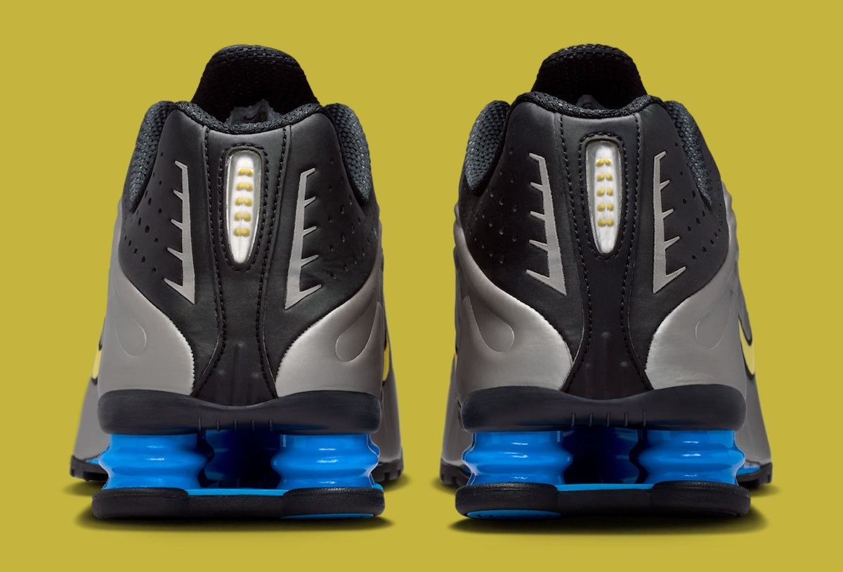 Nike Shox R4 Brazil avec tige en mesh noir et empiècements synthétiques, détails Canary et Light Photo Blue, amorti Nike Shox et semelle extérieure en caoutchouc.
