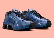 Nike Shox R4 Iridescent avec tige en cuir synthétique à finition irisée, détails réfléchissants, amorti Nike Shox à quatre colonnes et semelle extérieure en caoutchouc.