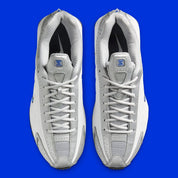 Nike Shox R4 Orlando avec tige en cuir synthétique blanc, détails noirs et bleus, amorti Nike Shox à quatre colonnes et semelle extérieure en caoutchouc.