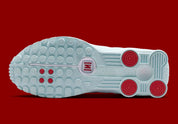Nike Shox R4 Puerto Rico avec tige Glacier Blue en cuir synthétique, détails University Red et Metallic Silver, graphismes PR, porte-bonheur Vejigante et amorti Nike Shox à quatre colonnes.