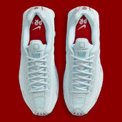 Nike Shox R4 Puerto Rico avec tige Glacier Blue en cuir synthétique, détails University Red et Metallic Silver, graphismes PR, porte-bonheur Vejigante et amorti Nike Shox à quatre colonnes.