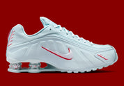 Nike Shox R4 Puerto Rico avec tige Glacier Blue en cuir synthétique, détails University Red et Metallic Silver, graphismes PR, porte-bonheur Vejigante et amorti Nike Shox à quatre colonnes.