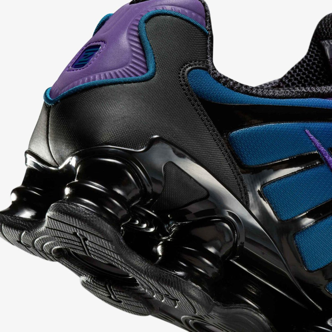 Vue zoomée sur les détails arrières de la Nike Shox TL Voltage Purple avec tige en mesh respirant, renforts synthétiques moulés, détails Voltage Purple et semelle Nike Shox intégrale offrant amorti et stabilité.