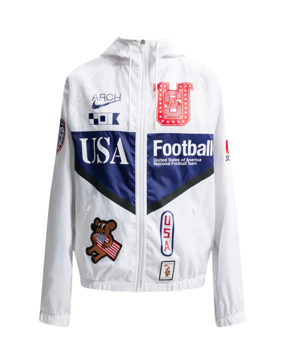 Nike x USMNT x V.A.A. Anthem Jacket blanche avec détails Deep Royal Blue, graphismes V.A.A., patchs collaboratifs et coupe ample.
