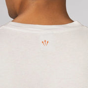 Nike x NOCTA Opal Reels Tee White, tee-shirt blanc en coton avec illustration paysage et pêcheur, détails multicolores et Swoosh orange.