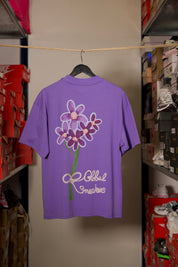 T-shirt Global Sneakers Concrete Bloom en coton premium 230 g fabriqué au Portugal, avec illustration florale signature sur la poitrine et dans le dos, disponible en Noir, Blanc, Lila et Verdeau.
