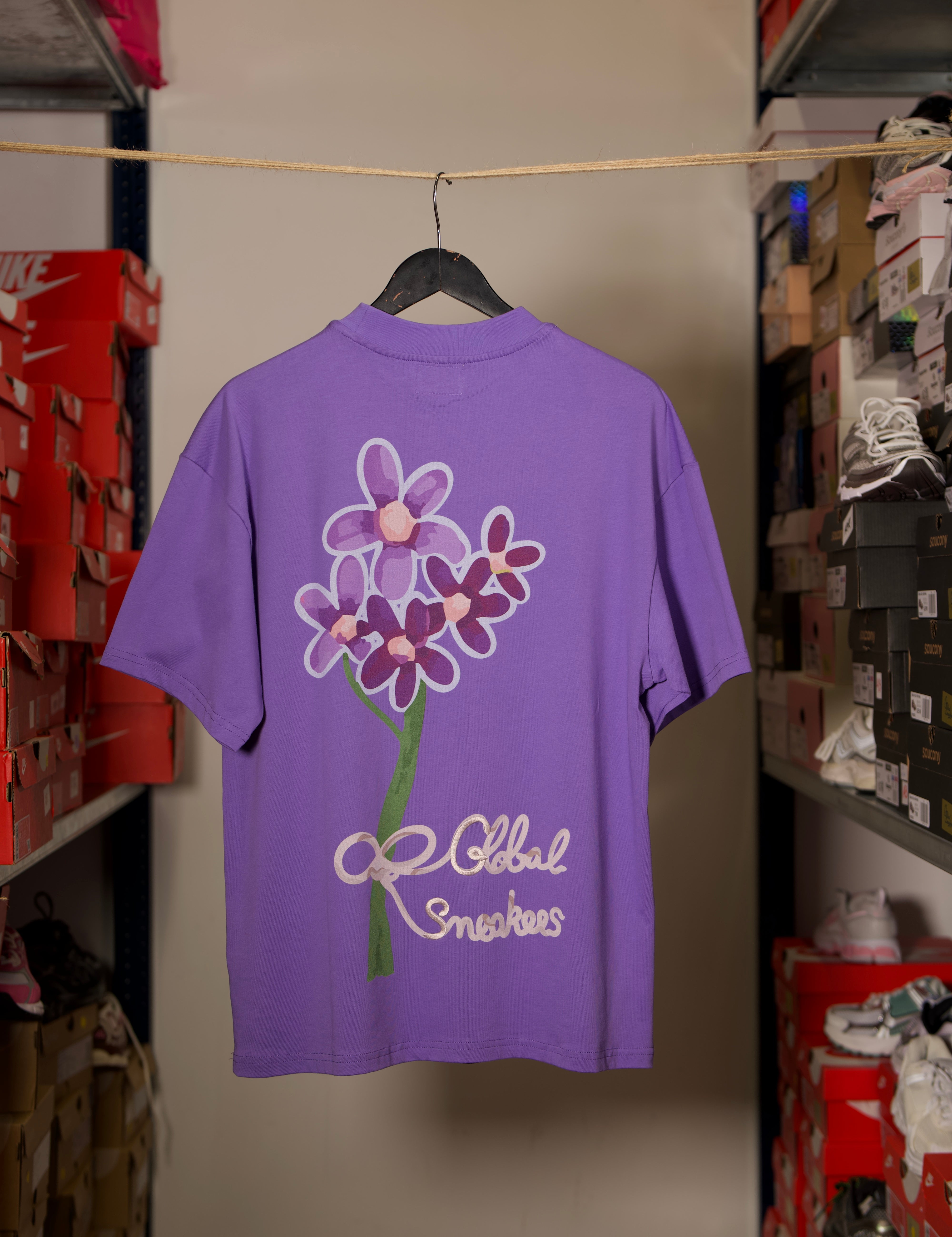 T-shirt Global Sneakers Concrete Bloom en coton premium 230 g fabriqué au Portugal, avec illustration florale signature sur la poitrine et dans le dos, disponible en Noir, Blanc, Lila et Verdeau.