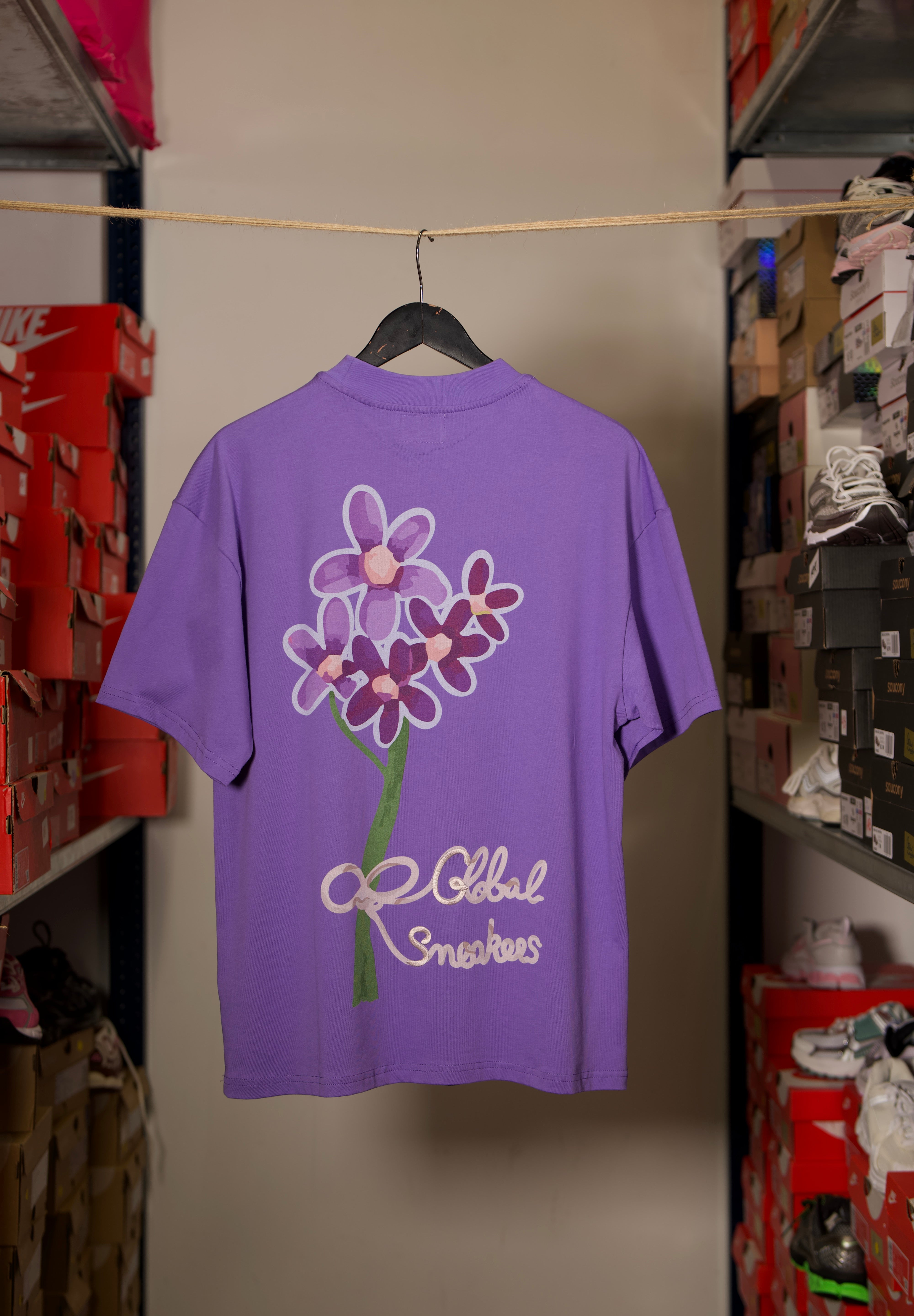 T-shirt Global Sneakers Concrete Bloom en coton premium 230 g fabriqué au Portugal, avec illustration florale signature sur la poitrine et dans le dos, disponible en Noir, Blanc, Lila et Verdeau.