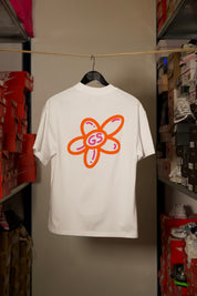 T-shirt Global Sneakers Unity Bloom en coton premium 230 g fabriqué au Portugal, avec logo brodé sur la poitrine et fleur GS en Puff Print au dos, disponible en Blanc, Rose, Vert et Lila.