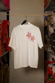 T-shirt Global Sneakers Concrete Bloom en coton premium 230 g fabriqué au Portugal, avec illustration florale signature sur la poitrine et dans le dos, disponible en Noir, Blanc, Lila et Verdeau.