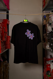 T-shirt Global Sneakers Concrete Bloom en coton premium 230 g fabriqué au Portugal, avec illustration florale signature sur la poitrine et dans le dos, disponible en Noir, Blanc, Lila et Verdeau.