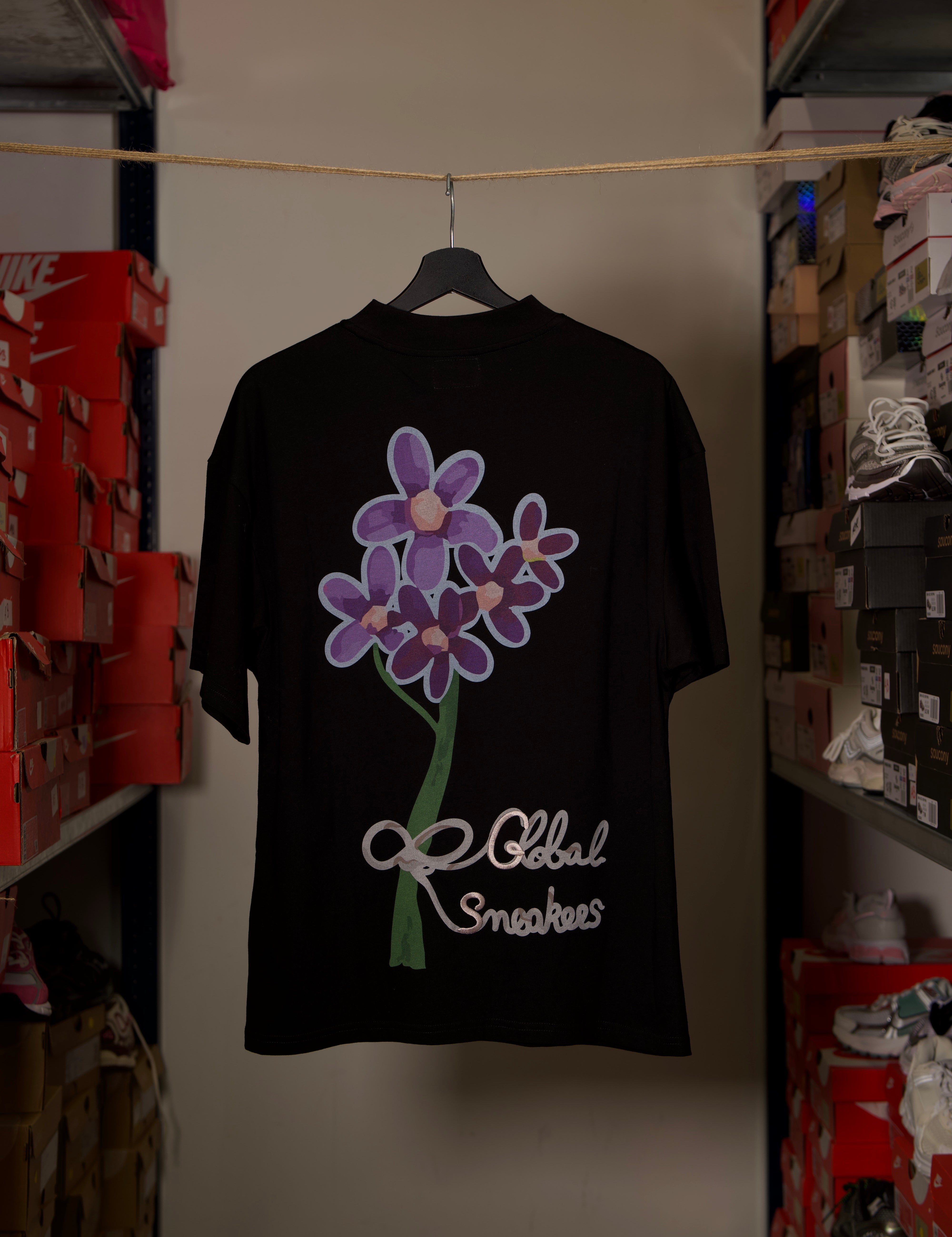 T-shirt Global Sneakers Concrete Bloom en coton premium 230 g fabriqué au Portugal, avec illustration florale signature sur la poitrine et dans le dos, disponible en Noir, Blanc, Lila et Verdeau.