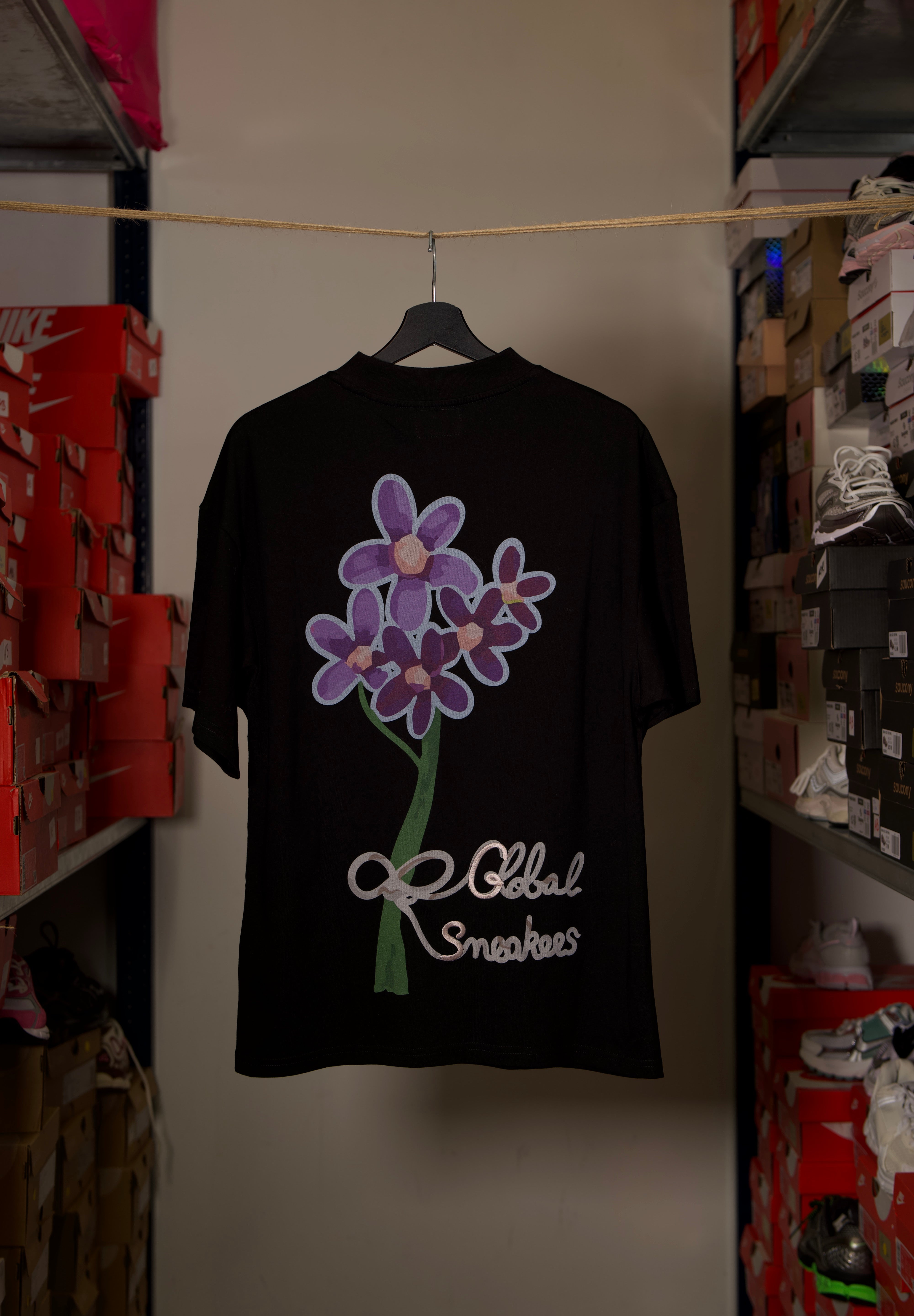 T-shirt Global Sneakers Concrete Bloom en coton premium 230 g fabriqué au Portugal, avec illustration florale signature sur la poitrine et dans le dos, disponible en Noir, Blanc, Lila et Verdeau.