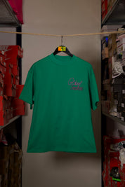 T-shirt Global Sneakers Unity Bloom en coton premium 230 g fabriqué au Portugal, avec logo brodé sur la poitrine et fleur GS en Puff Print au dos, disponible en Blanc, Rose, Vert et Lila.