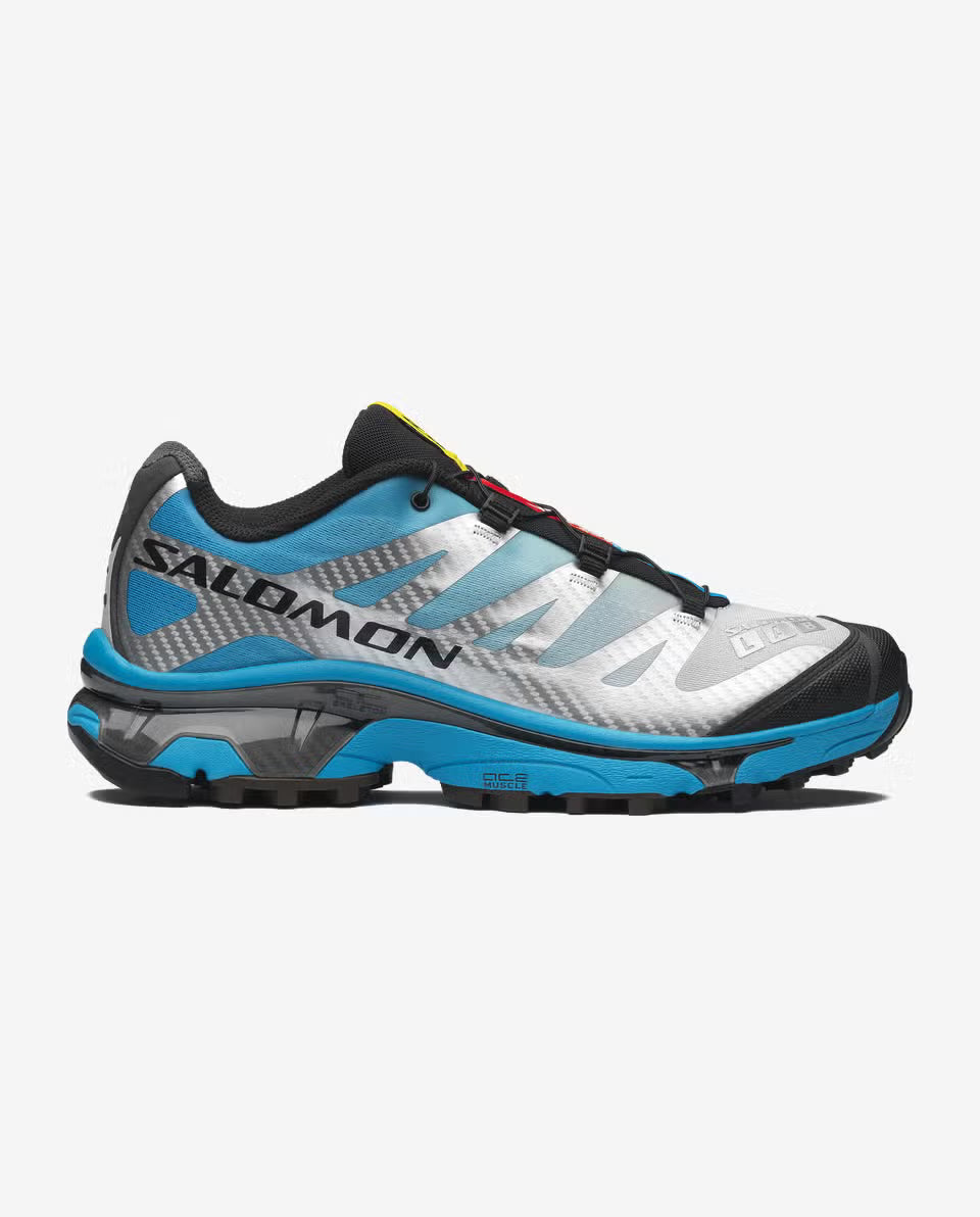 Salomon XT-4 OG Silver Black Transcend Blue avec tige en maille respirante argentée, renforts noirs, détails Transcend Blue, système Quicklace™ et semelle Contagrip® à crampons.