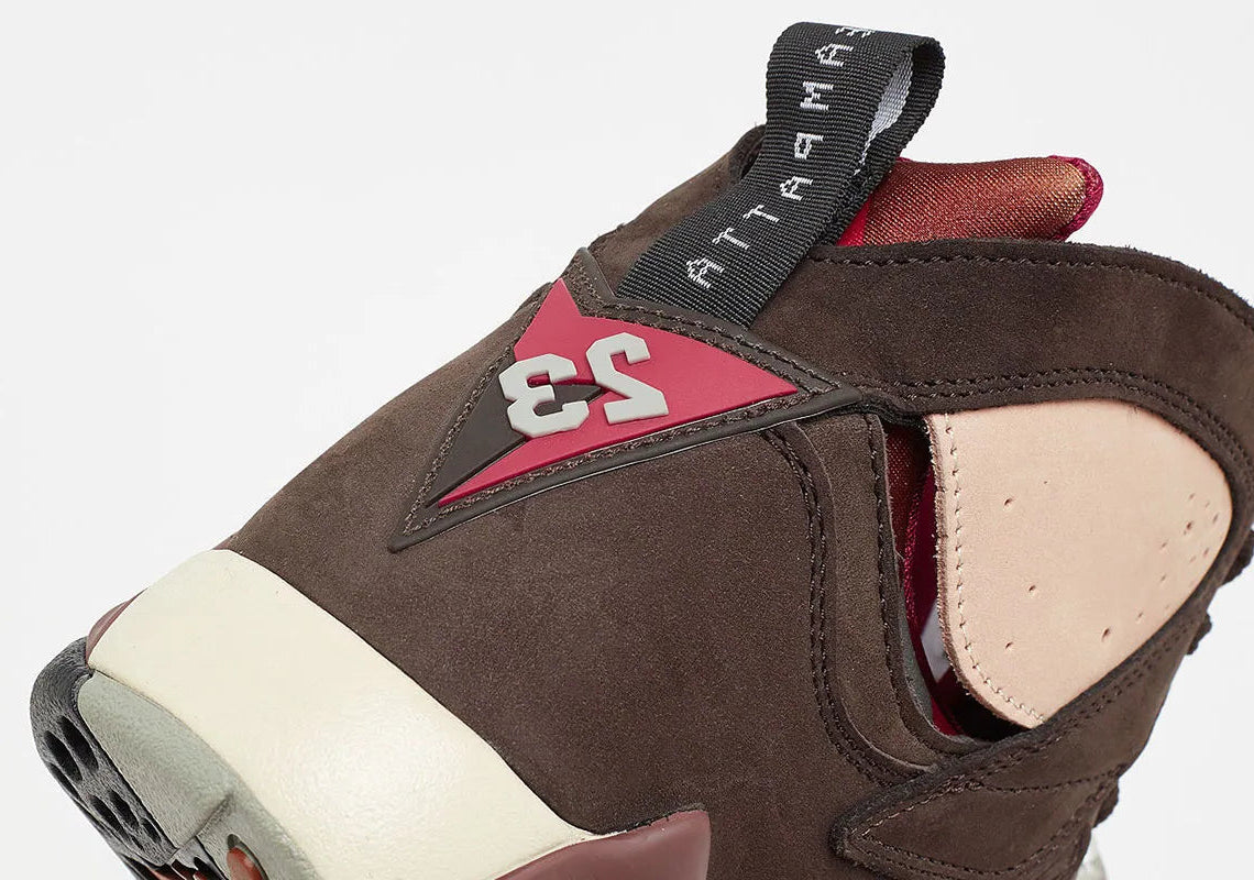 Vue zoomée sur l'arrière de la Air Jordan 7 Retro Patta Shimmer AT3375-200 en cuir et suède marron avec accents Tough Red, Jumpman brodé et branding Patta sur la semelle.