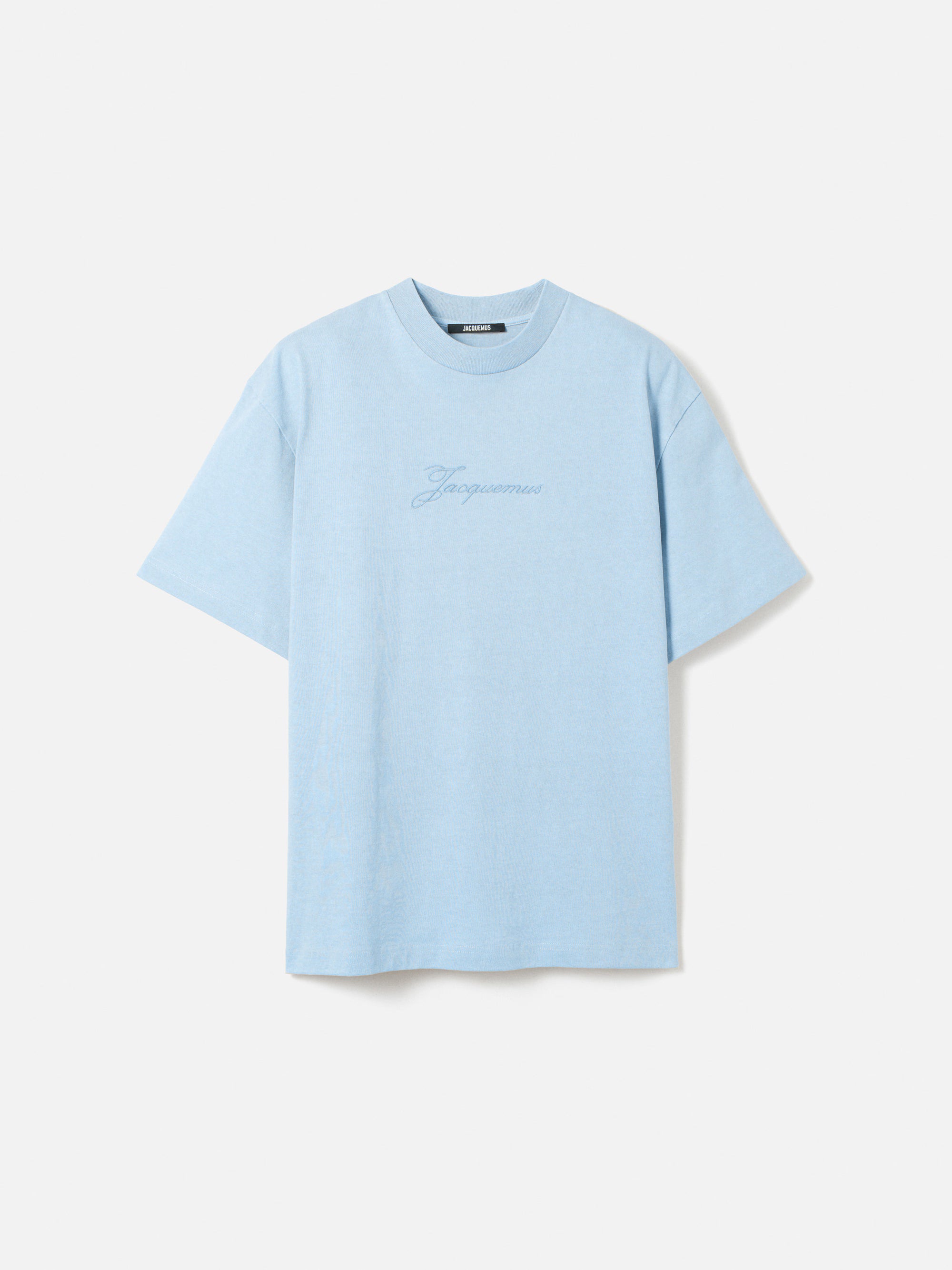 Tee-shirt JACQUEMUS Pigmento Bleu Ciel en coton pigmenté à coupe boxy avec manches aux coudes et logo Signature brodé.